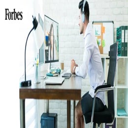Image of a man on a virtual meeting from his home office wearing a dress shirt and athletic shorts.