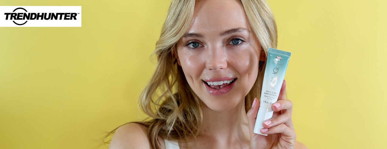 Image of a woman holding a bottle of Age IQ InvisiBloc Sunscreen Gel.