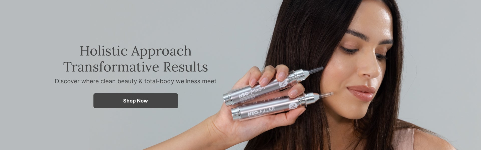 A woman holding a two Neo-FILLER tubes to her face. Accompanying text mentions a Holistic Approach with Transformative Results. Shop now to discover where clean beauty & total-body wellness meet.