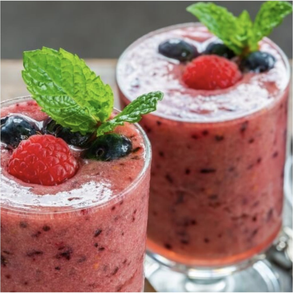 Two glasses containing berry smoothies.