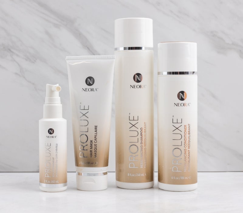 Image of Neora ProLuxe Hair Care Set which includes Rebalancing Shampoo and Conditioner, Hair Mask, Scalp Treatment on a marble background