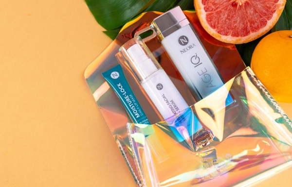 The Summer Skin Essentials Set shown on a pale orange background with citrus fruit.