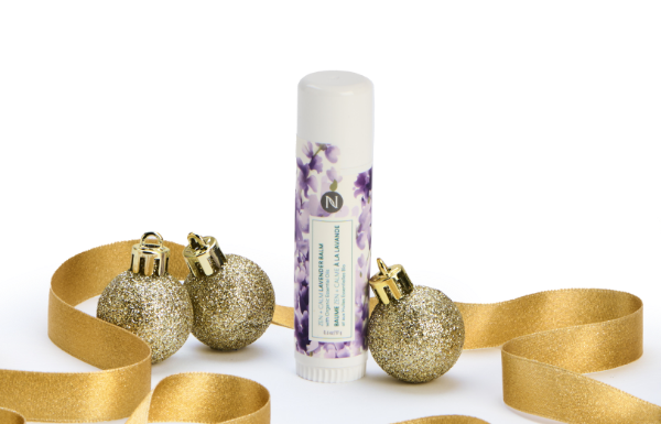 Neora’s Zen + Calm Lavender Balm surrounded by gold ribbon and ornaments.