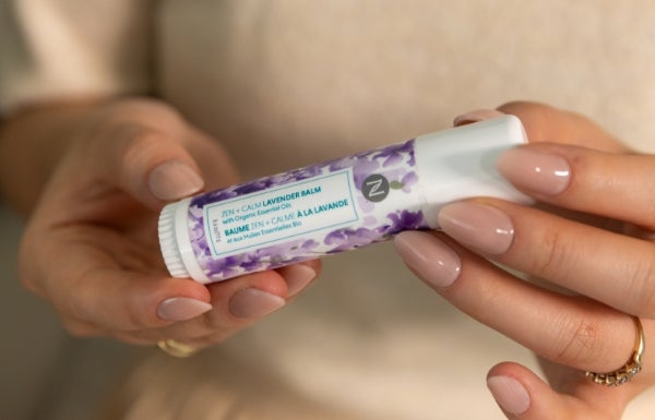 A close-up of a woman holding Neora’s Zen + Calm Lavender Balm in her hands.