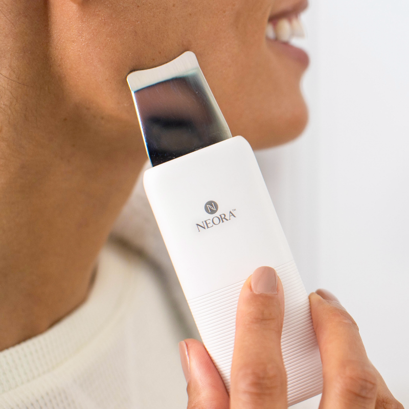 Neora’s limited-time only Ultrasonic Skin Renewal Facial Device is shown along woman’s face.