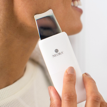 Neora’s limited-time only Ultrasonic Skin Renewal Facial Device is shown along woman’s face.