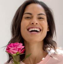 A close-up of a smiling woman’s face holding the SIG-1723 concentrated serum.