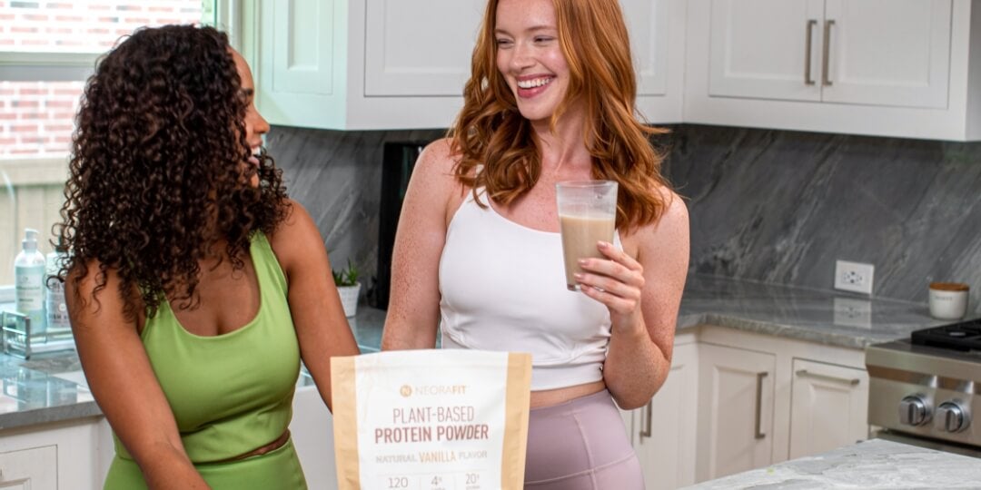 Two women talking with NeoraFit protein powder shakes in their hands.