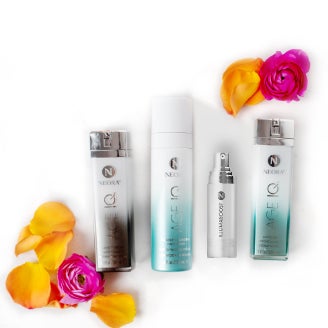 Aparecen cuatro botellas en el set Age IQ® Limpiar, Corregir, Proteger que incluye: Neora Age IQ Crema para Noche, Iluminador y Protector IllumaBoost, Limpiador de Doble Acción y Age IQ Crema para Día. 