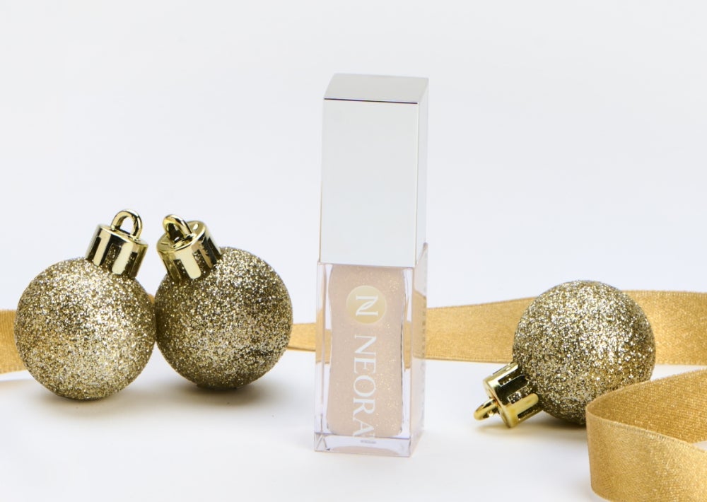 New limited-edition Shimmer Lip Oil. Achieve softly-shimmer, glamorously glossy and intensely hydrated lips for $77 retail or $64 with SmartShop. Background imagery includes a Shimmer Lip Oil container surrounded by gold ribbon and ornaments.