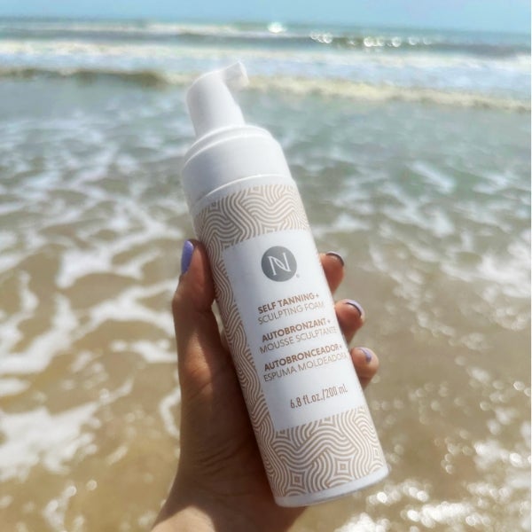 Photo collage showing a bikini-clad woman posing with the 3-in-1 Self Tanning and Sculpting Foam, sunkissed legs on a beach with the product bottle, and the product on a beautiful, wave-lapped beach.